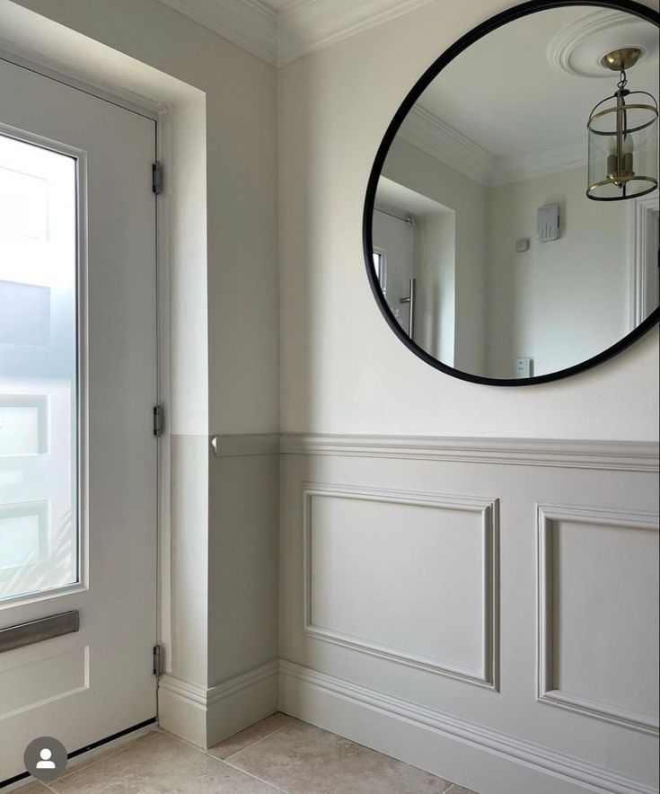 a mirror hanging on the side of a wall next to a door in a room