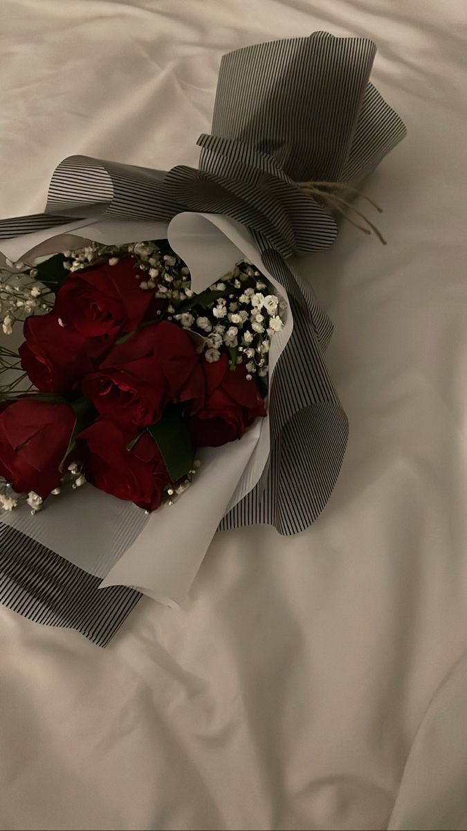 a bouquet of red roses on a white sheet