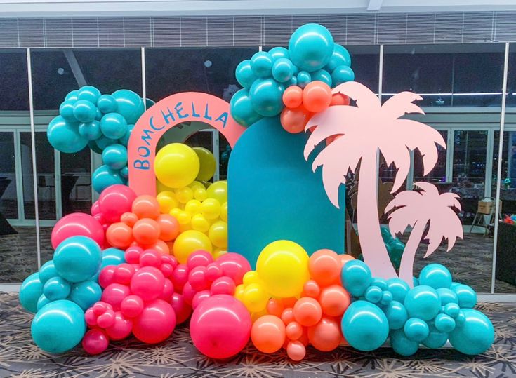 there are many balloons in the shape of a house and palm trees on the table