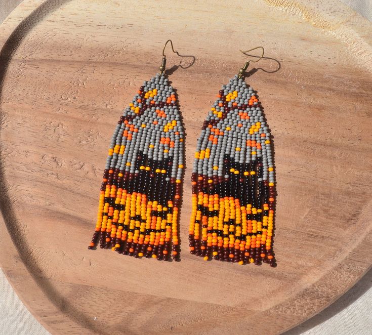 two pairs of beaded earrings on top of a wooden board