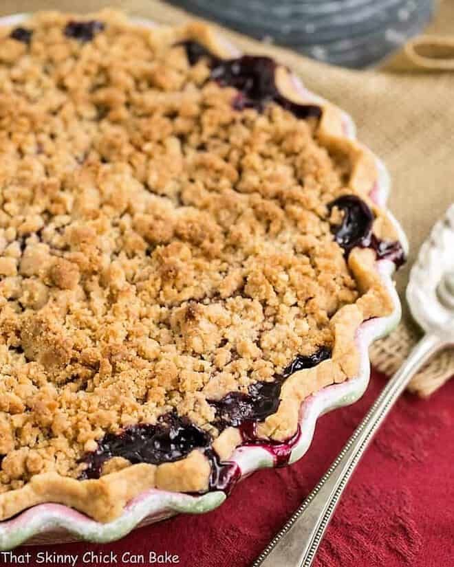 a close up of a pie on a table with a fork and bowl in the background