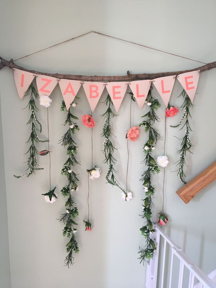 a baby crib with flowers and greenery hanging from it