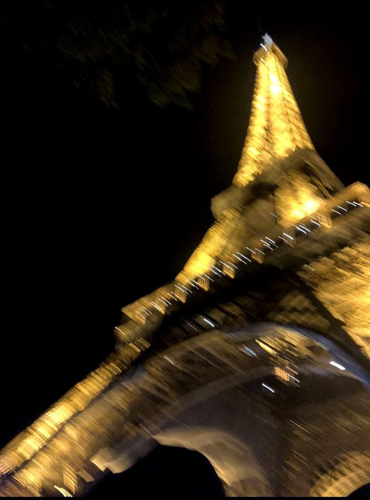 the eiffel tower is lit up at night