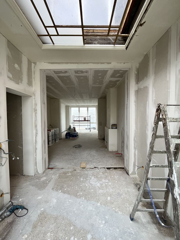 an empty room with ladders and windows in the middle, surrounded by scaffolding