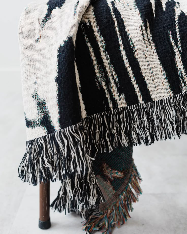 a black and white blanket sitting on top of a chair