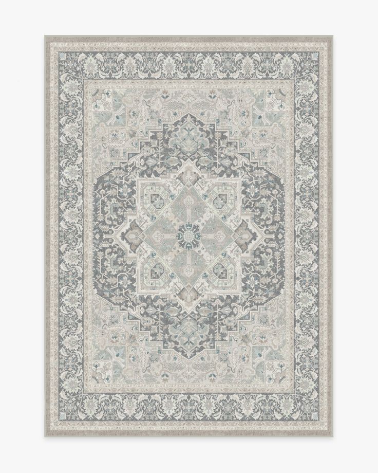 a rug with an ornate design on the front and back side, in grey tones