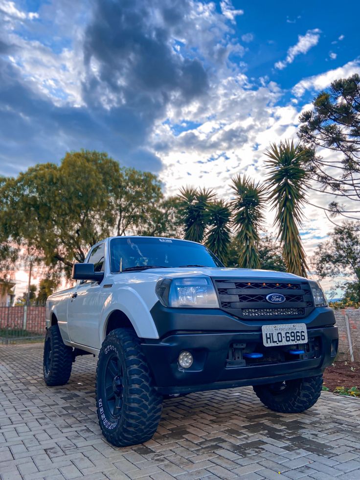 a white truck parked on top of a brick road