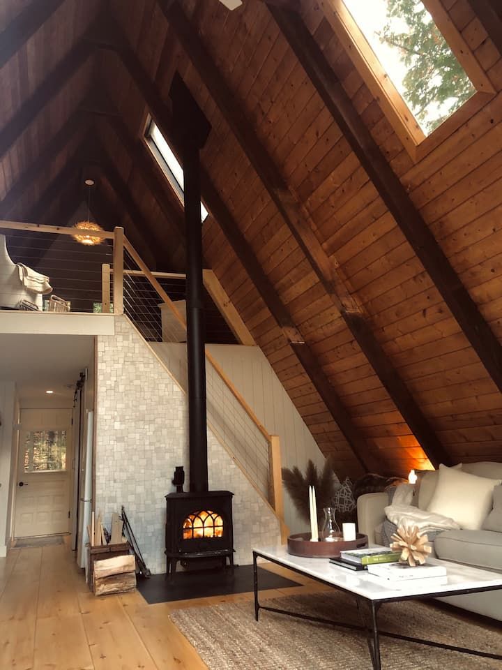 a living room filled with furniture and a fire place in the middle of a loft