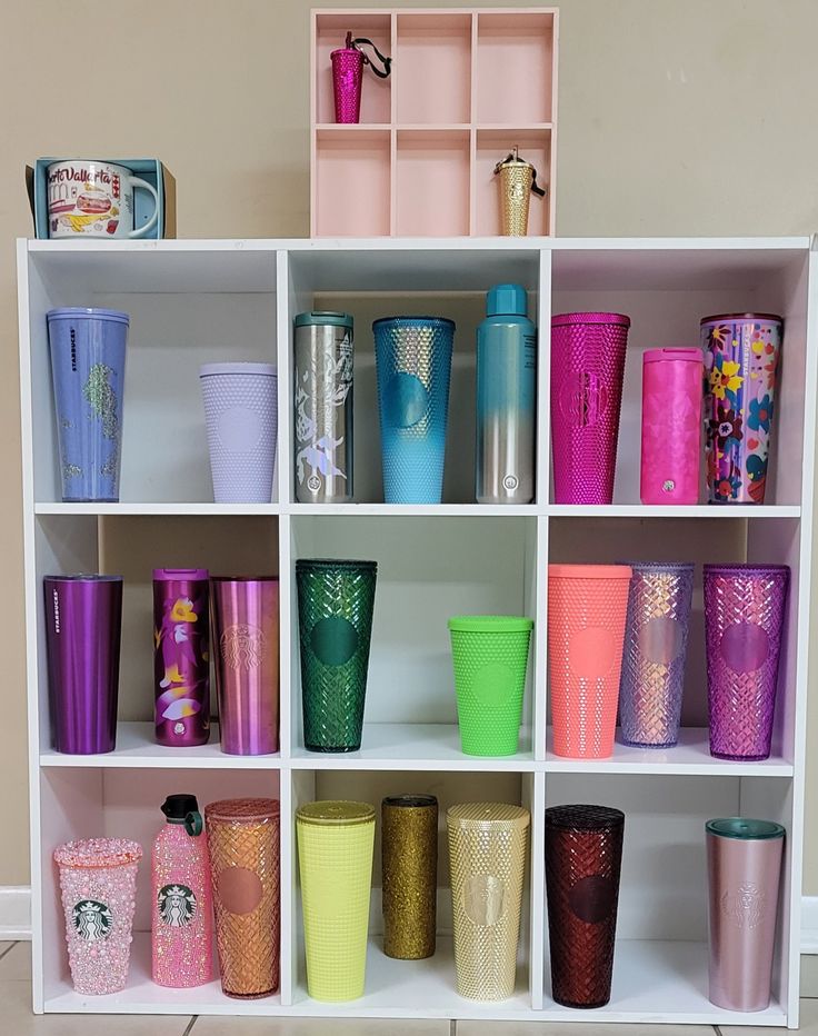 a shelf filled with lots of different colored cups