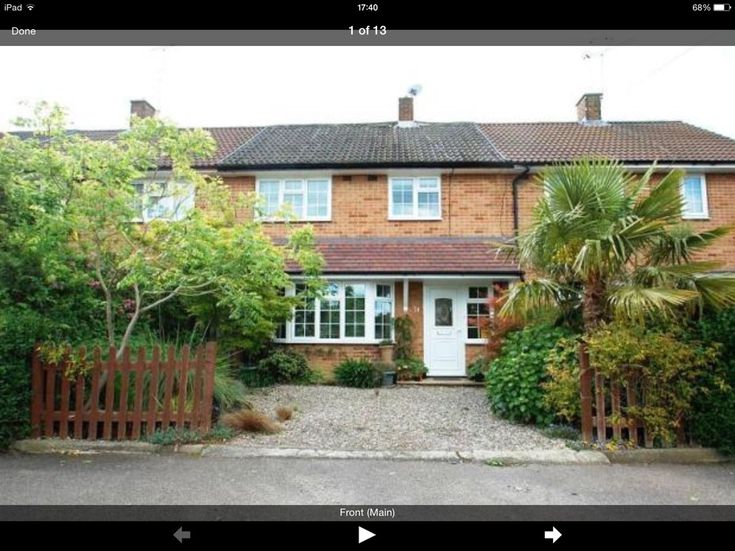 an image of a house that is on the street with trees and bushes around it