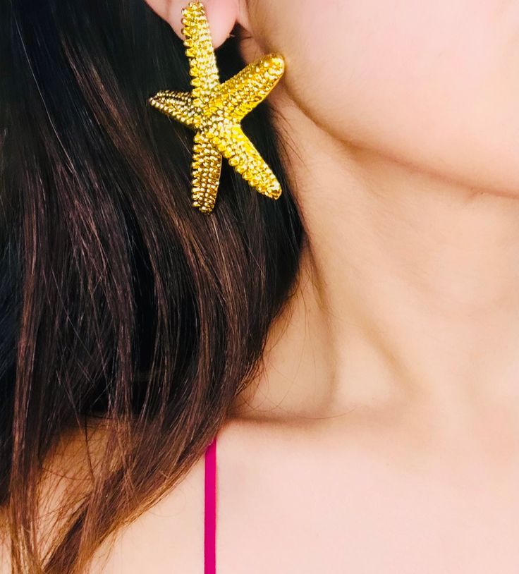 Wear them with confidence, whether it's for a special occasion or just to add a touch of sparkle to your everyday life. Our Star Earrings are a reminder that you are a shining star in your own right, capable of achieving anything you set your mind to. With every purchase, you're not just buying a pair of earrings; you're investing in yourself and embracing your unique identity. Dimensions (LxW): 2.16 inches x 2.16 inches Estimated Delivery: 3-4 Days. Gold Star-shaped Crystal Earrings For Party, Glamorous Sparkling Clip-on Earrings For Gift, Elegant Star Shaped Hoop Earrings Gift, Starfish Charm Jewelry For Parties, Party Jewelry Starfish Charm, Starfish Charm Party Jewelry, Elegant Star Charm Earrings For Party, Sparkling Star-shaped Crystal Earrings, Elegant Party Earrings With Star Charm