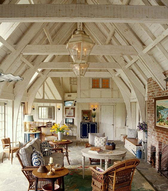 a living room filled with furniture and a fire place in the middle of an open floor plan