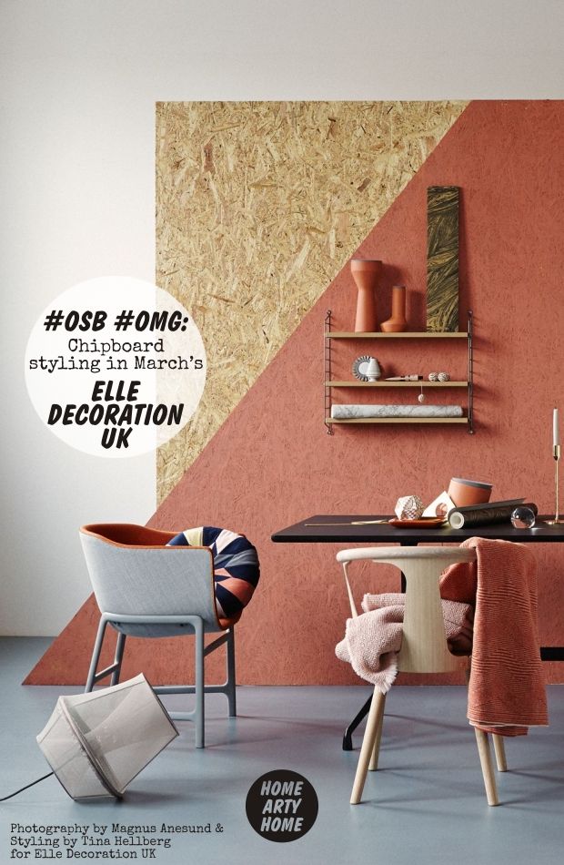 a dining room with an orange wall and white chairs in front of the table,