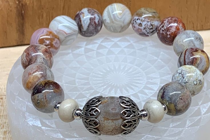 12mm Laguna Lace Agate, DZI bead, 5x8mm River Stone, 4mm SPL beads, Antique Silver Bead Caps, Strung on Stretch Cord. Agate Beaded Bracelets With Spacer Beads, Silver Agate Stretch Bracelet, Silver Bead, Lace Agate, Bead Caps, Stretch Bracelet, Stretch Bracelets, Diy Jewelry, Antique Silver