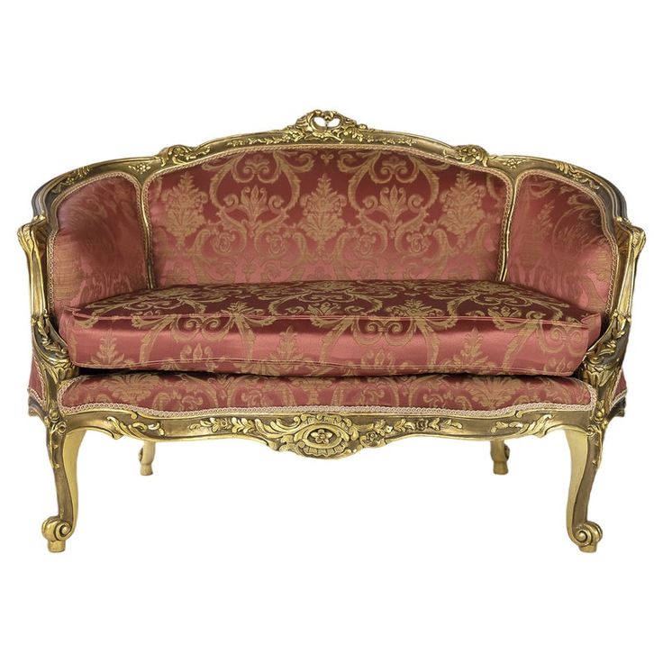 an ornately decorated couch with gold trimmings and red upholstered fabric