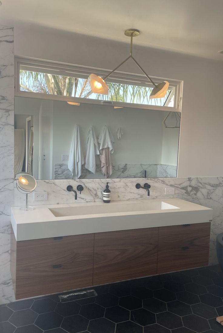 a bathroom with two sinks and a large mirror over it's counter top,