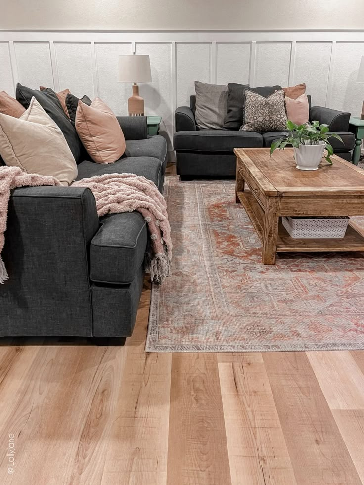 a living room with two couches, a coffee table and a rug on the floor