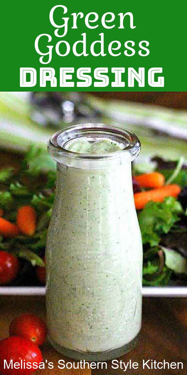 green goddess dressing in a glass jar on a wooden table with tomatoes and lettuce