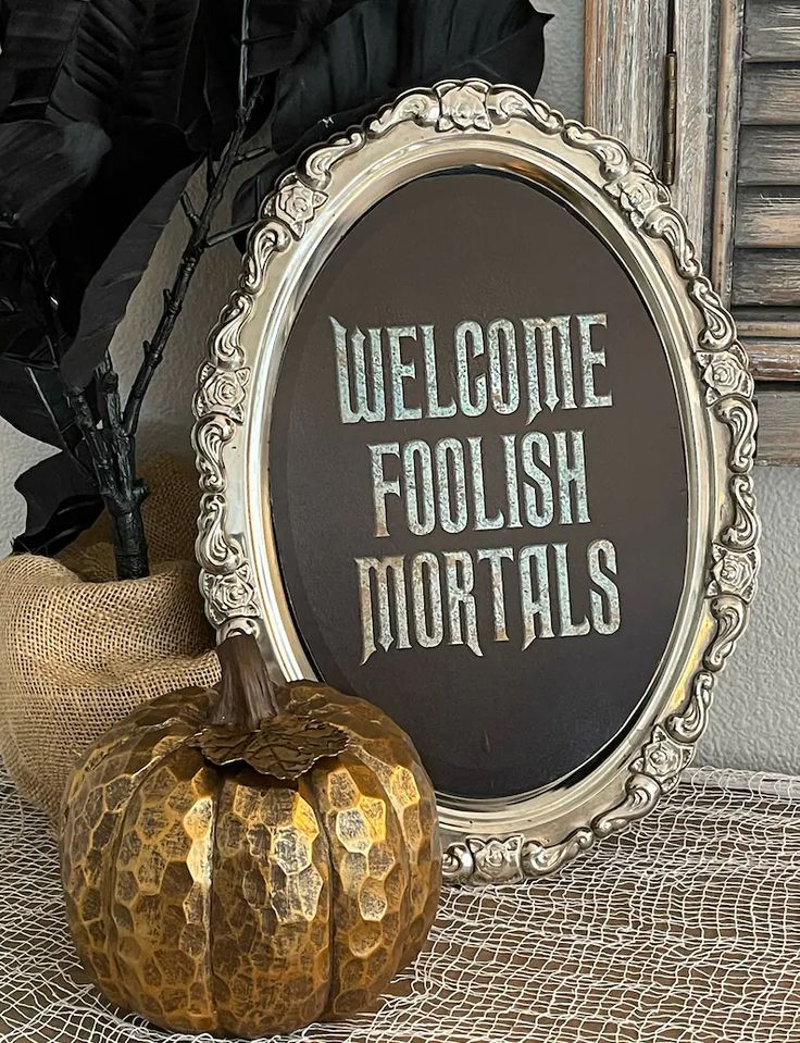 a sign that says welcome foolish mortals next to a pumpkin