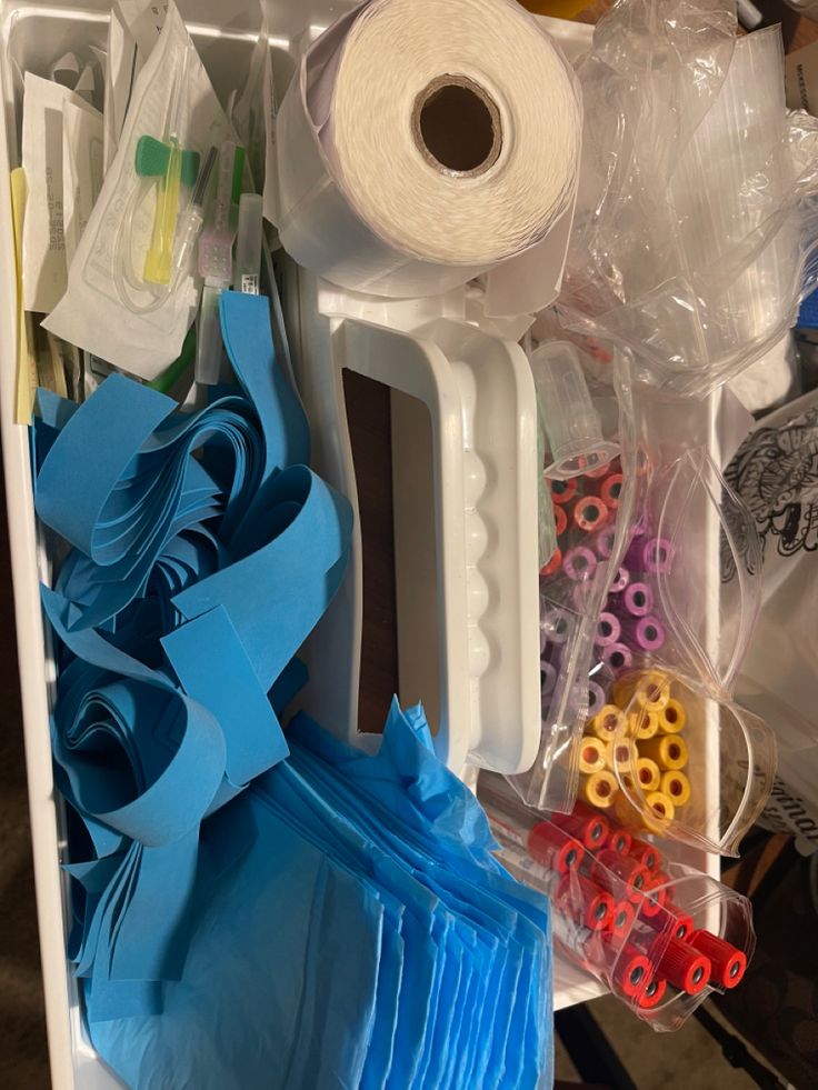 several different types of crafting supplies in a plastic container with scissors and spools