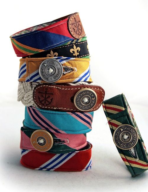 several different colored belts stacked on top of each other with one button in the middle