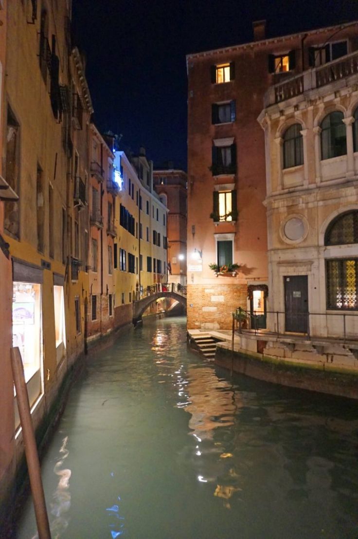 a narrow canal runs between two buildings at night