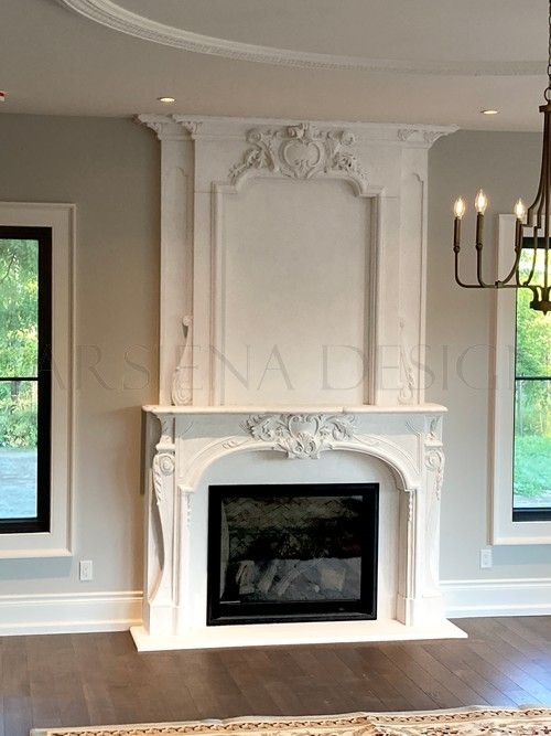 an empty living room with a fireplace and chandelier