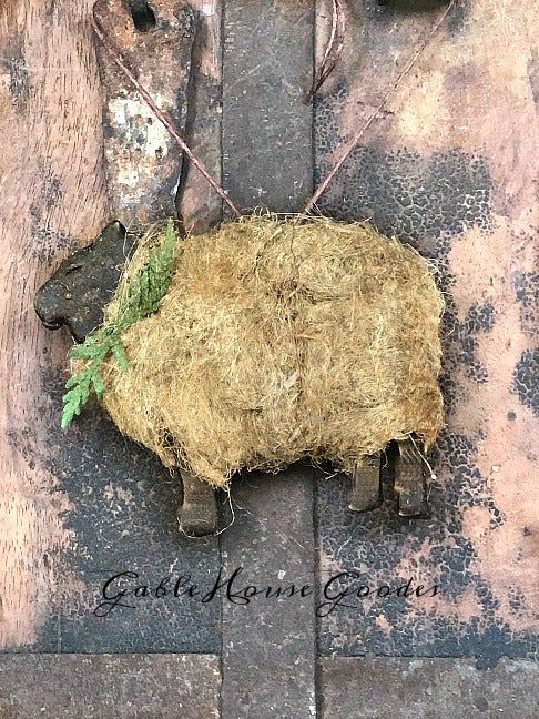 a sheep laying on top of a pile of hay