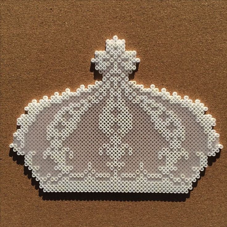 a white cross stitched purse sitting on top of a brown surface