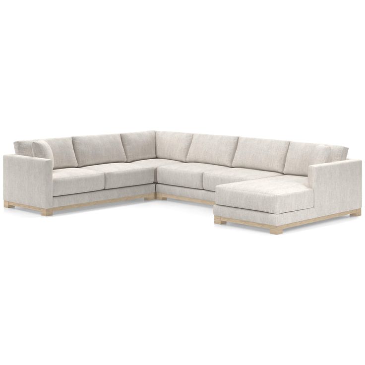 a white sectional couch sitting on top of a wooden floor