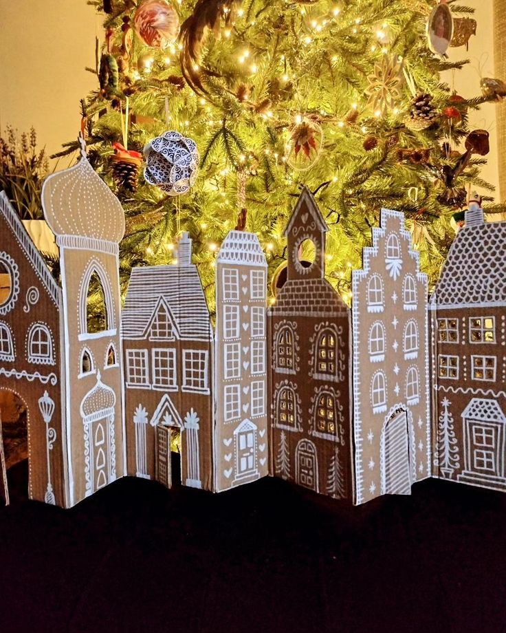 a christmas tree is in front of a paper cut out city scene