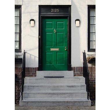 a green door sits in front of a white building