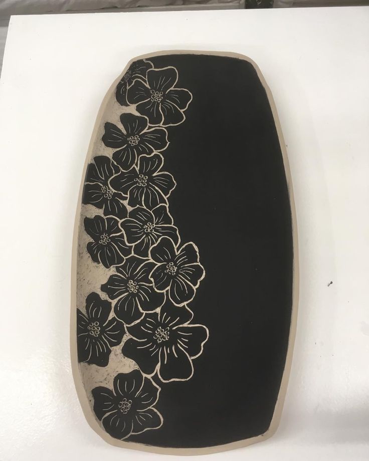 a black and white vase with flowers on it