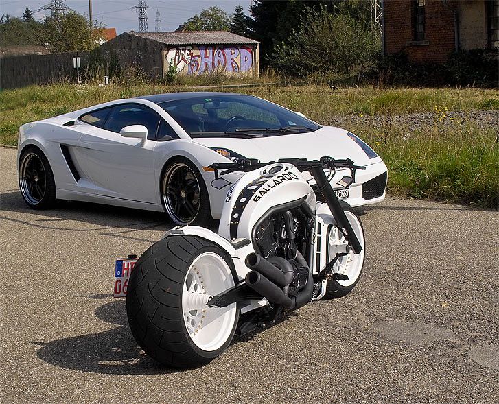 a white sports car is parked on the side of the road next to a motorcycle