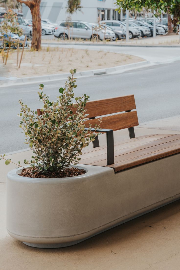 a wooden bench sitting on top of a cement planter