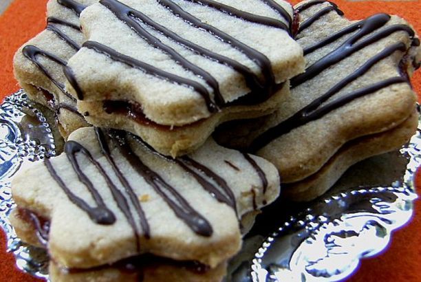 cookies with chocolate drizzled on them are sitting on a silver platter