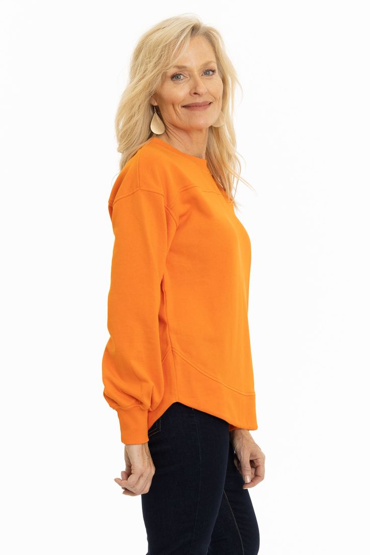 A orange relaxed fit crewneck sweatshirt with front and back yoke detailing. A soft French terry fabric features balloon sleeves with ribbed cuff and rounded hemline. 80% cotton/ 20% poly. Casual Sweater With Balloon Sleeves And Ribbed Cuffs, Casual Balloon Sleeve Sweater With Ribbed Cuffs, Spring Sweatshirt With Ribbed Neckline, Orange Ribbed Cuffs Sweatshirt For Fall, Orange Relaxed Fit Sporty Sweatshirt, Spring Tops With Ribbed Cuffs And Balloon Sleeves, Spring Balloon Sleeve Tops With Ribbed Cuffs, Fall Crew Sweatshirt With Elastic Cuffs, Fall Tops With Elastic Cuffs