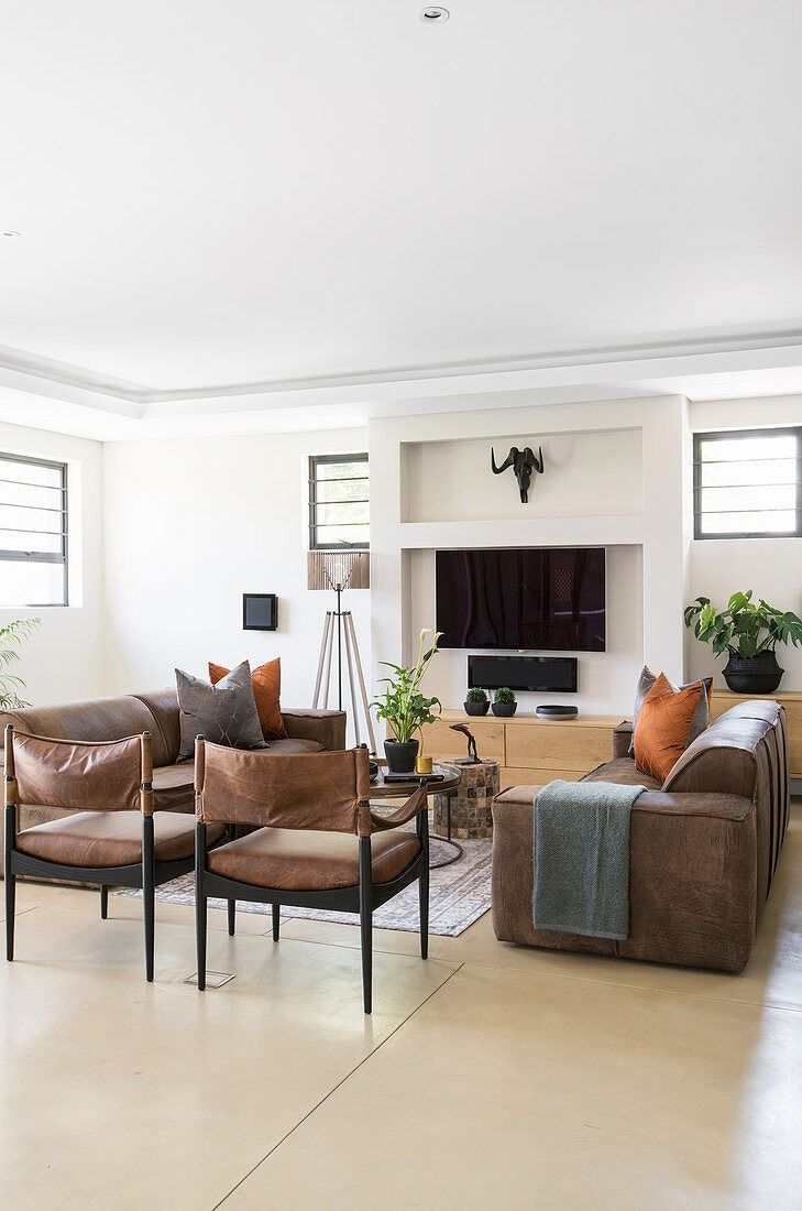 a living room filled with furniture and a flat screen tv mounted to the side of a wall