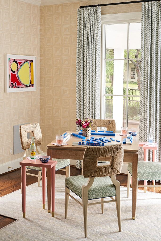 a dining room table with chairs around it and a painting on the wall behind it