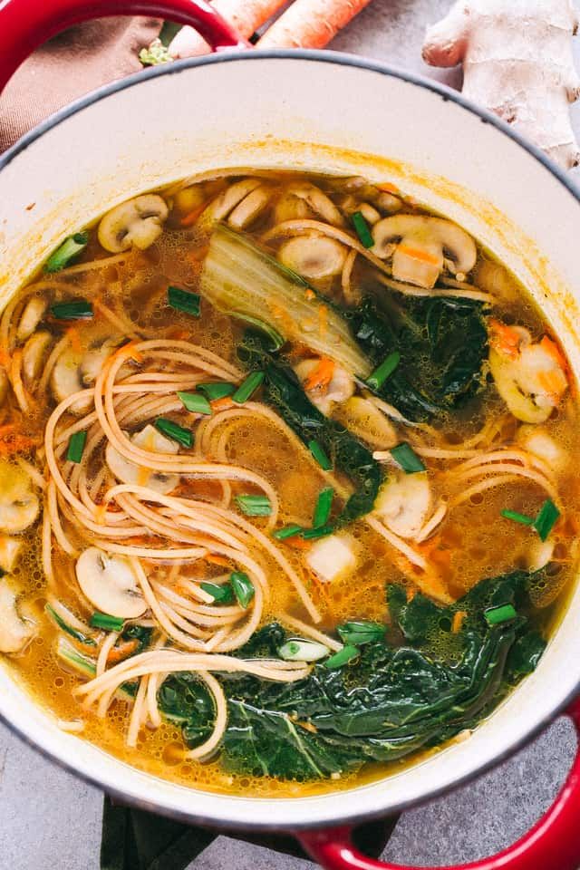 a pot filled with noodles and vegetables on top of a table