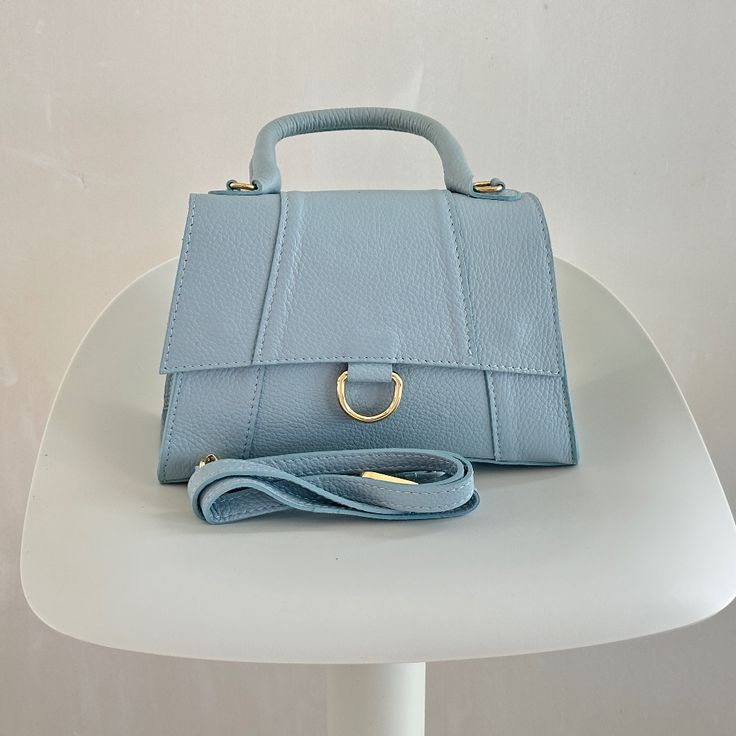 Brand New, Light Blue Never Used Top Handle Shoulder Strap Included One Interior Zipper Pocket Toggle Closure Interior Lining Height 6" Width 9" Depth 3.5" Handle 3.5" Shoulder Adjustable Please Look At The Pictures Carefully And Ask Questions If You Have Any Concerns. We Have Disclosed Everything And Send The Exact Items That Is Shown. Luxury Light Blue Leather Shoulder Bag, Blue Square Leather Box Bag, Light Blue Formal Crossbody Bag, Formal Light Blue Crossbody Bag, Blue Satchel Flap Bag For Shopping, Elegant Light Blue Shoulder Bag With Gold-tone Hardware, Light Blue Formal Shoulder Bag, Blue Crossbody Flap Bag With Top Carry Handle, Blue Flap Shoulder Bag With Top Carry Handle