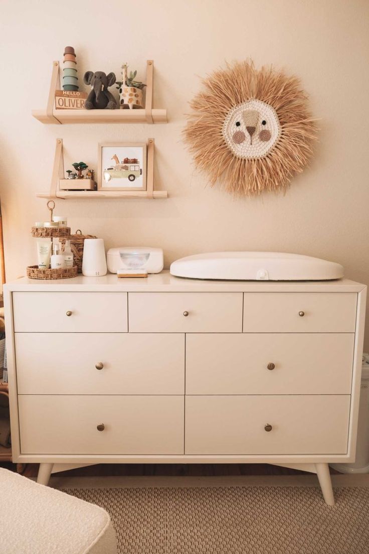 a baby's room with a crib, dresser and shelves on the wall