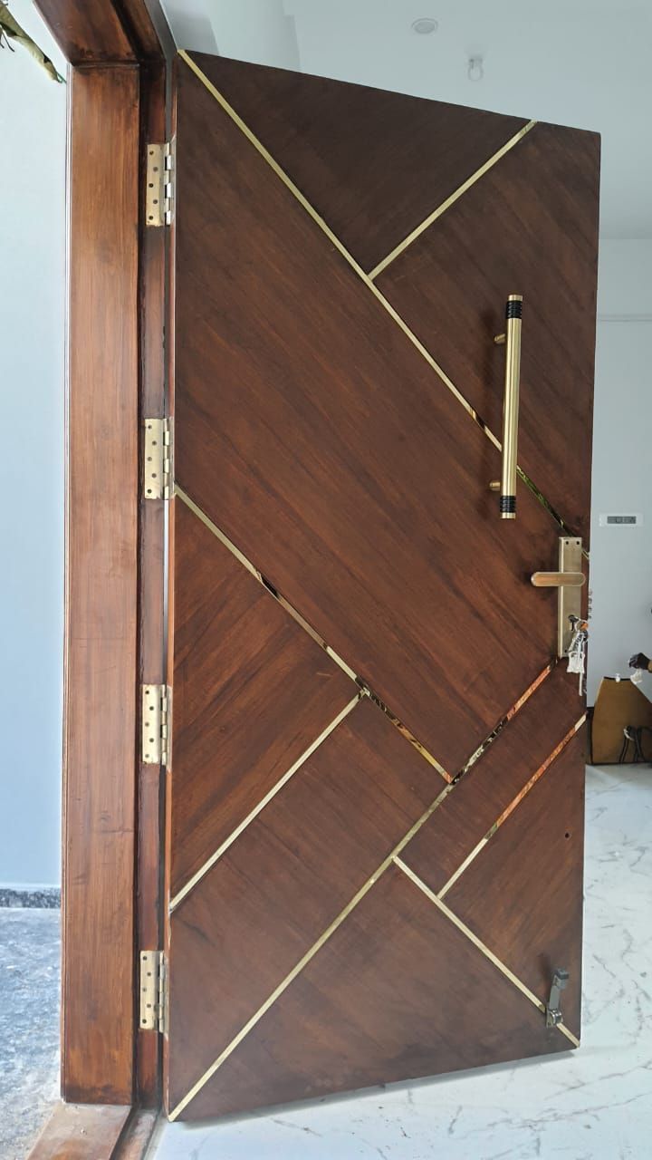 a wooden door with gold trim and handles