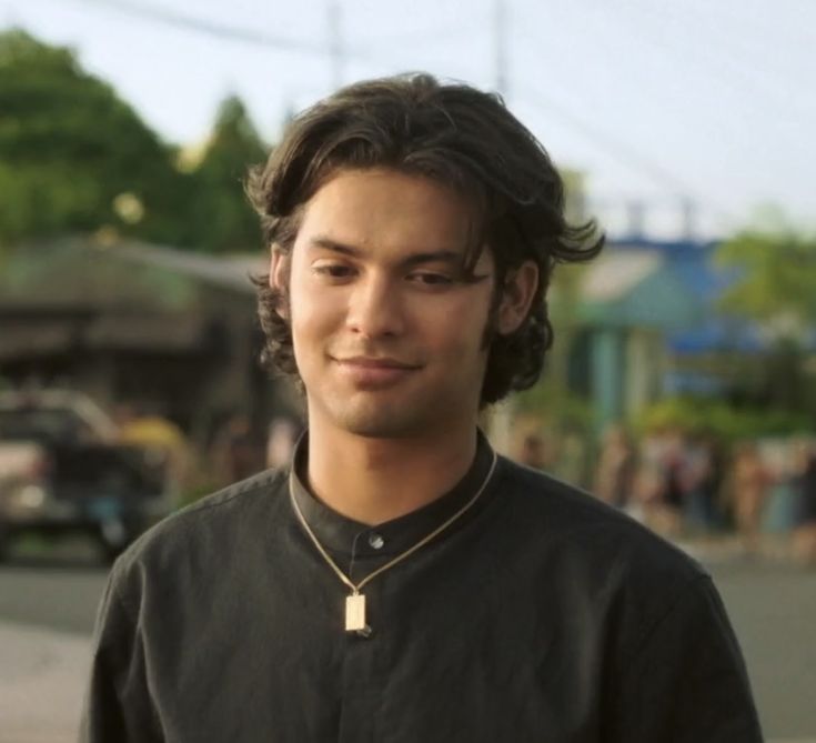 a young man is standing in the street