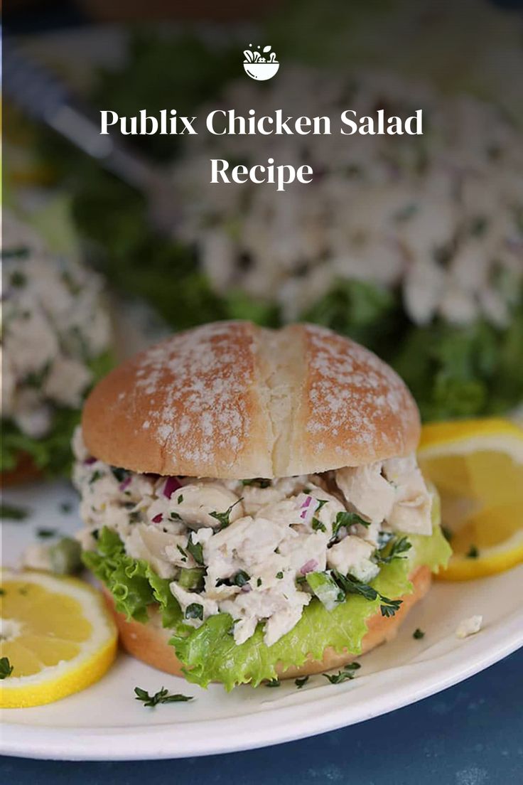 a chicken salad sandwich on a plate with lemon slices