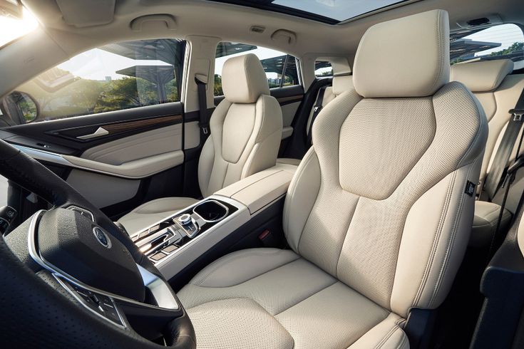 the interior of a car with all white leather and black trim, including two rows of seats