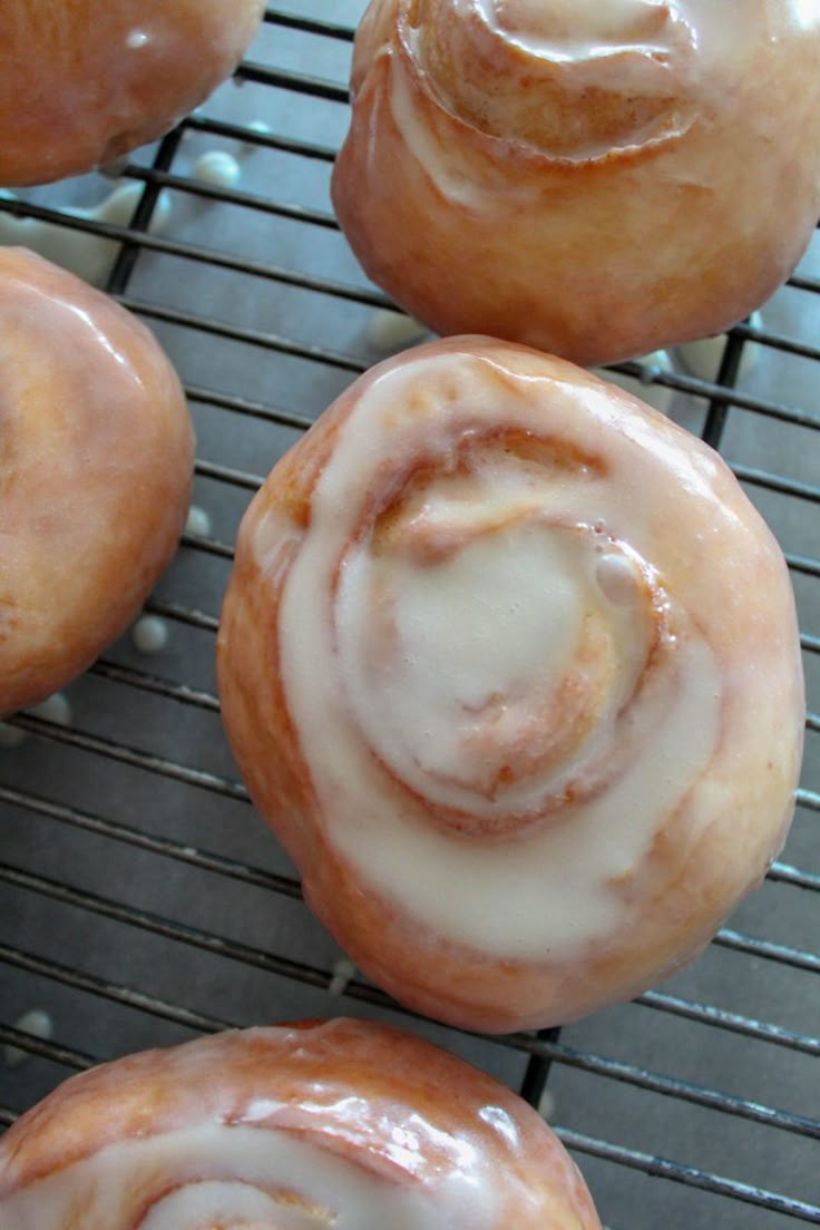 several glazed donuts sitting on a cooling rack