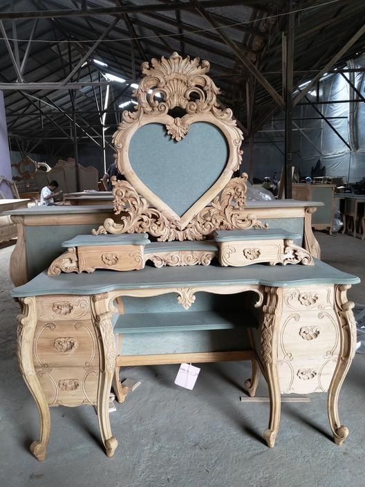 an ornate desk with a heart shaped mirror on top