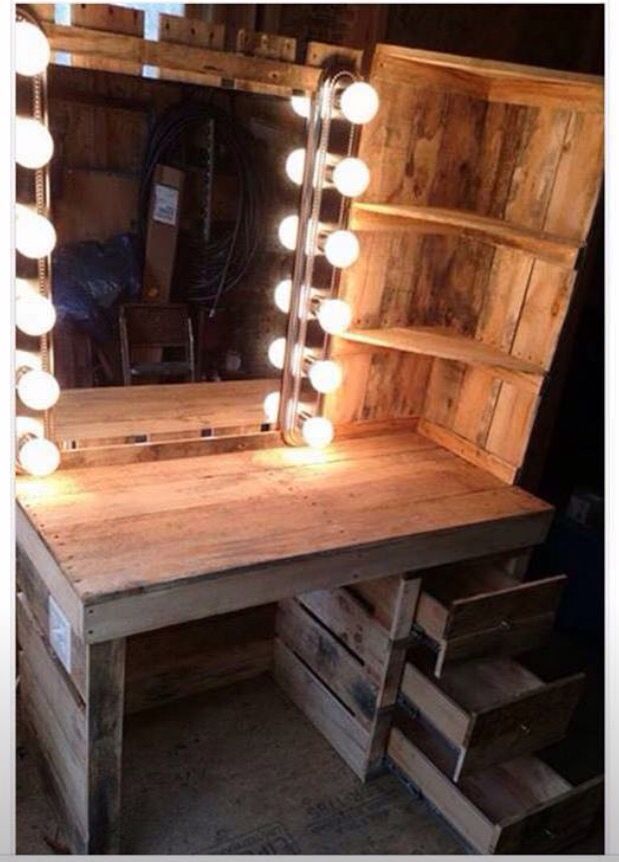 a wooden desk with a lighted mirror on it