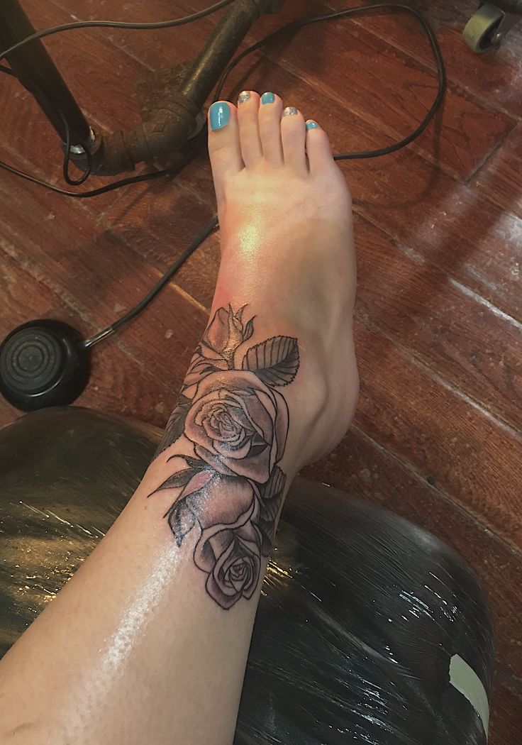 a woman's foot with a rose tattoo on her left leg and the bottom part of her arm